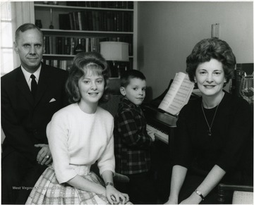 Family seated around piano, children are Paula and Tommy.