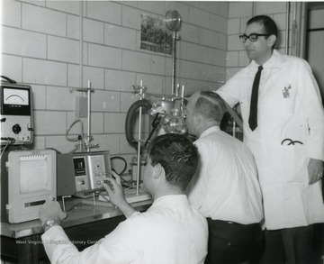 A snapshot from coalworkers pneumoconiosis symposium: shown here is a subject on a respiratory machine, while two men in lab coats monitor.  Russakoff is father right.