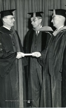 West Virginia University President Irvin Stewart confers Honorary Doctor of Science Degree to Dr. Vannevar Bush as Dr. Conant looks on.
