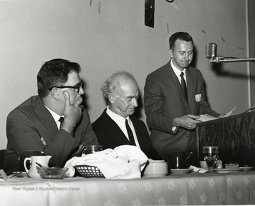 'Two time winner of the Nobel Peace Prize, Linus Pauling (center), is introduced by moderator Vincent Traynelis, chairman of the WVU Dept. of Chemistry (right), as symposium committee chairman Guy Stewart, WVU prof. of Journalism (left), watches at the Science-Writing symposium Oct. 6, 1967.