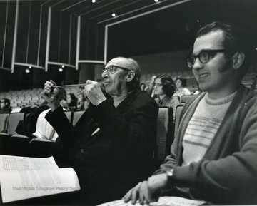 Aaron Copland sits next to a student in concert hall at Creative Arts Center. 
