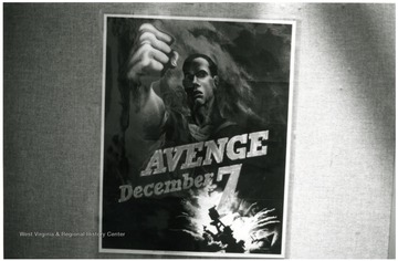 Exhibit in second floor gallery of Mountainlair. Poster says, 'Avenge December 7'.
