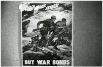 Exhibit in second floor gallery of Mountainlair. Poster says, 'Attack, attack, attack, buy more war bonds'.