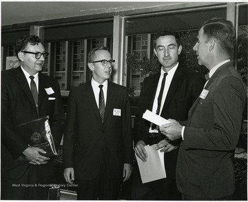 'Dr. Albert R. Hibbs, senior staff scientist at the California Institute of Technology Jet Propulsion Laboratory (second from right), chats with panelists who reacted to his Oct. 6, 1967 address in the Science-Writing symposium.  Panelists include: Jerome Fanucci, chairman of the WVU dept. of Aerospace Engineering (left); Bos Johnson, news director of WSAZ-TV in Huntington (second from left); and moderator J. Richard Toren, UPI Regional Executive in Pittsburgh.'
