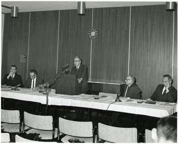 'Dr. Moody Prior, Graduate Department of English at Northwestern University (center), is shown speaking at the Dec. 6, 1967 Future of Graduate Education at WVU seminar.  Seminar planning committee chairman John Ludlum (left) listens with panelists Delmas Miller, WVU Prof. of Education and Chairman of Secondary Education (second from left); Homer Evans, WVU Prof. of Agricultural Economics and Associate Director of the WVU Agricultural Experiment Station (second from right); and Virgil Peterson, WVU Prof. of English (right).'