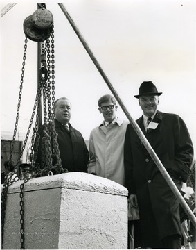 'WVU President James G. Harlow (left), WVU student body president Jim Mullendore (center), and member of the WVU Board of Governors Pat Hamilton (right) are shown at the burial of the time capsule in December 1967