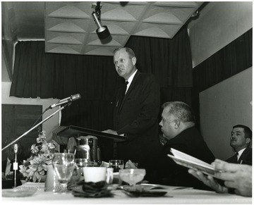 Joel Hannah, Executive Secretary of the Morgantown Chamber of Commerce, (speaking) welcomes participants at the June 28-29, 1967 symposium on 'Man and His Community,' as main speaker Harry Boswell, former states' representative of the Appalachian Regional Commission (foreground) and Charles Haden II, chairman of the symposium planning committee (back right) listen.'