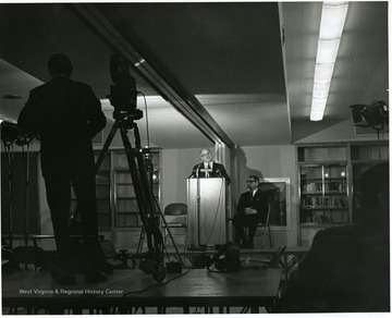 'Harvard University historian Oscar Handlin speaks at Feb. 23, 1967 lecture as part of the "Lessons of History" symposium, as planning committee chairman John Caruso listens in the background.'