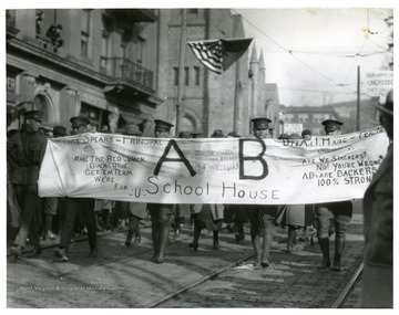 Sign reads, '[unreadable] Spears, Principal. Make the Red & Black, Black & Blue, Get 'em team, we're for U.  AB School House. Dr. A. J. Hare, Teacher.  Are we slackers" No. You're Wrong.  ABs are backers, 100% strong.'