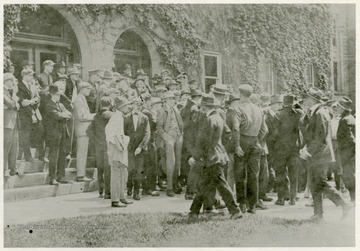 Students protest the WVU administration's decision not to cancel the spring semester final exams as many other colleges had decided to do after the United States officially entered World War I on April 6th. Most male students would either enlist or be drafted as soon as possible forcing them to leave school before the end of the semester.