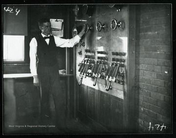 An unidentified man demonstrates a "switch board" at Martin Hall.