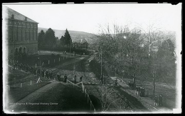 Students exit from chapel in Reynolds Hall; it is taken from the porch of Agricultural Experiment Station.