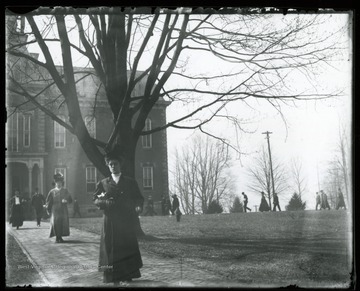 Foot traffic flows around Woodburn Circle; In the background is Martin Hall with the clock tower which now sits on Woodburn Hall.