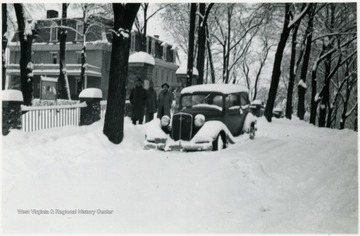 Storer students stand next to snow covered car during the great snow of March 7, 8, 9, 1941.
