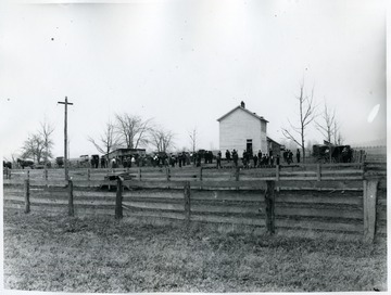 On a wooden fence runs along the school, an advertisement 'BARGAINS IN FURNITURE AT L.E. KRAMERS RONCEVERTE' reads. .