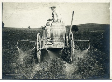 A man and a little girl on spraying cart.