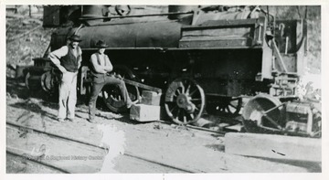 'Cab of junked engine removed and used on other.  John Noon and Pat O'Brian shown scrapping one engine.'