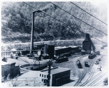 'Engine terminal, round house, coaling station, water thanks, machine shops, turntable and office building ca. 1950.  The Guyan river runs between the shops and W. Va. Highway 10.  This picture was produced just before the diesel came online with the C&amp;O.  All the shops are visible except the lower end where the pittracks existed.'
