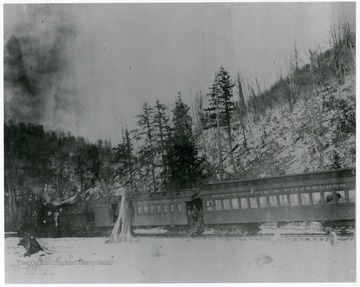 Locomotive engines of West Virginia &amp; Pittsburgh Railroad #30 stops in snowy mountains; engineers, operators and passengers are seen at entrances.