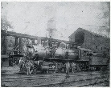 A C.&amp; O. locomotive in a train yard with workers a round.