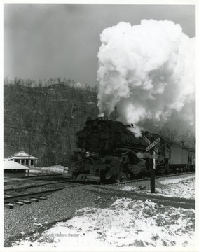 Image from the collection of the Chesapeake and Ohio Historical Society. 'CSPR 3700 H-6, 2-6-6-2 Mallet #1307 with coal train at railroad / highway grade crossing near Logan, W. Va. - condensing white exhaust.' 
