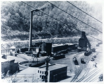 'Engine terminal, roundhouse, coaling station, water tanks, machine shops, turntable and office building.  The Guyan river runs between the shops and W. Va. highway 10.  This picture was produced just before the diesel came online with the C.&amp; O. all the shops were visible except the lower end where the pitt tracks existed.'