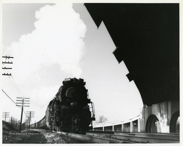 Image from the collection of the Chesapeake and Ohio Historical Society. 'CSPR-3261: K-4 Kanawha #2714 eastbound with empties out of Russell, Ky.  coming under highway overpass east end of town.'