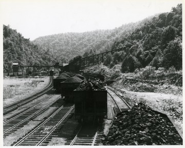 Image from the collection of the Chesapeake and Ohio Historical Society. 'CSPR-312: C.&amp; O. Mallet switching loaded hoppers at Stanaford, W. Va. Mine tipple.  Coal cars are most prominent in photo.'