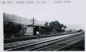 A man crossing rail roads to get to an waiting area.