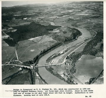 'Bridge in foreground on U.S. Highway No. 121, which was constructed in 1930 and 1931 to replace Jacksons ferry; old ferry-boat still visible.  About an inch above left end of bridge is old shot tower about 100 feet in height.  Austinville in left distance.  Looking west at mile 182.2.'