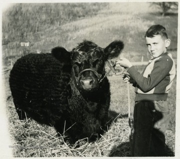 'Billy Swisher, Lost Creek, and his Angus Steer, which placed first, and was Reserve Champion Angus Steer of the show, at the Pittsburgh Live Stock Show -- December 1944.'