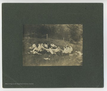 Inscribed on back, 'Taken on the 7th of July 1906 when we had a picnic up the river (via launch with a trailer?) to lock 11, 15 in party. Mr. and Mrs. Farcum chaperoning. Bill Whitham took picture. Petie Martin, Marie Buxton (Martin), Jack Berry, Margaret Buchanan (Cole), Ducky Davenport (Arthur J.), Mary Edwards, Bobby Reiner, Nell Steele (Faris), Annie Rogers (Cox), George Brown, Nan Brooke (Harold) Mr. Farcum (WVU Coach), Mrs. Farcum, Boaz Cox. (Dr.), 'Bobby' Reiner (Herman), Bill Whitham (Prof.), Jim Turner and Phinny Reiner were to have gone. Met at our house at two o'clock. Got back at ten-thirty.'