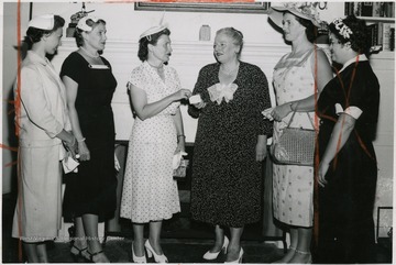 'Pearl Buck, famous Bucks county writer, shown second from right, as she received a membership card in the women's committee of the Delaware Valley Philharmonic Orchestra Association at her home in Dublin.  Mrs. Herbert Alger, chairman of the committee, makes the presentation.  With them (left to right) are Mrs. Donald Seip, Mrs. Oscar Norbeck, and at right, Gloria Gram.'