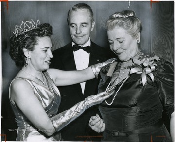 'State Rep. Bessie A. Buchanan, of New York (left), and Mayor-elect Richardson Dilworth present the Philadelphia cotillion Society's Amethyst Cross of Malta to Pearl S. buck, noted author, for her "unceasing activity in the cause of human rights" at seventh Christmas cotillion at Convention Hall.'