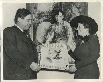 'Wendell L. Willkie, director of United China Relief, and Pearl S. Buck with poster to be used in drive for $5,000,000 for Chinese Relief.  In Background is a portrait of Mme. Chiang Kai-Shek, wife of the Chinese Centralissimo.'