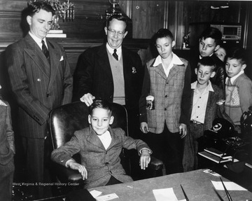 Robert C. Byrd in an office with children. 'Originals moved with R.C.B. Collection to the R.C. Byrd Center for Legislative Studies at Shepherd University.'