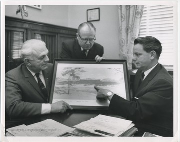 Senator Robert C. Byrd along with the Director of the U.S. Bureau of Prisons looking at a picture of the future site for a U.S. training school for boys.