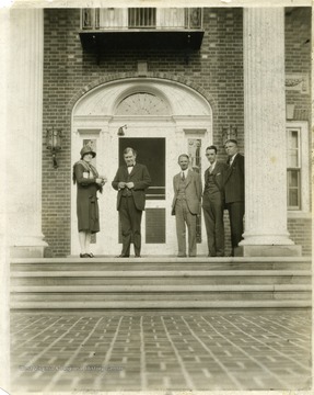 Governor Howard Gore and other unidentified individuals standing in front of the entrance to the Governor's Mansion.