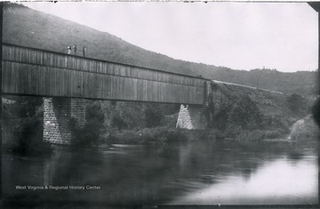 Gen. no. 82, neg. by W, No. 32. Monday 10 A.M. Ford in foreground deep. Dwight and two work men on bridge.