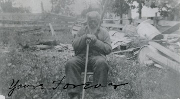 A portrait of a man with a walking stick sitting in a yard. 'From a Helen Ellison photo - copy of an original.'