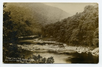 The photograph was taken from the east bank directly opposite Maple Run and the town of Rockley. Quarry Run empties into the Cheat at the bend in the river (left center). During the operation of the Cheat Iron Works(early 19th century), a saw mill and a boat yard were located close to the mouth of Quarry Run. Lumber from this mill was used to build flat boats to transport iron to markets. Information from A&amp;M 3848; Grafton, A. Edwin. Paper.