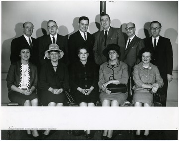 A group portrait of faculty, including Dr. Frasure (standing, far left).