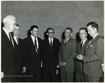 A portrait of Guy Stewart (third from left), Burkey Lilly (far right) and Joe Gluck (second from right) standing with four other men.