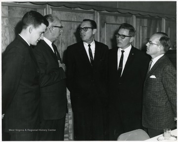 C.A. Arents (center) standing with four other individuals.