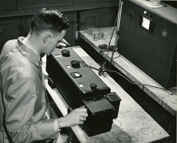 A photograph of a man working with an instrument in a laboratory.