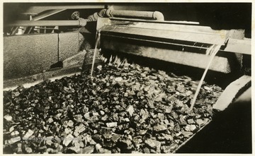 A photograph of coal being washed on a belt. 'Island Creek Coal Sales Co., Cincinnati, Ohio; The following cars of Pocahontas coal were shipped today for account of; P.C. Pocahontas Coal'