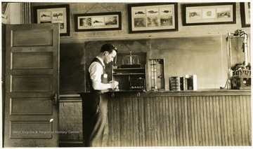 A photograph of a man in a classroom working with what appears to be laboratory equipment.