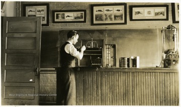 A man in a classroom working with what appears to be laboratory equipment.