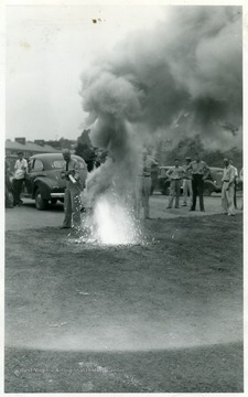 A photograph of a man putting out a fire as part of safety training.