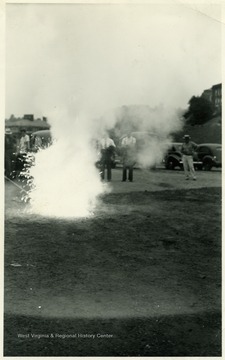 A photograph of a man putting out a fire as part of safety training.